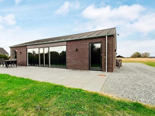 - un bâtiment en briques avec de grandes fenêtres et une terrasse dans l'établissement 6 person holiday home in Slagelse, à Slagelse