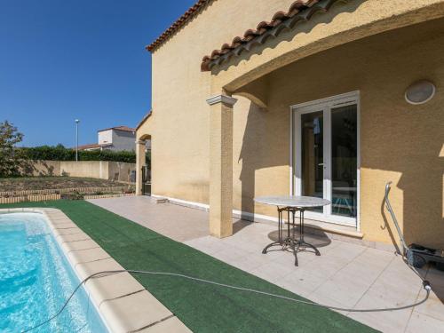 a house with a pool and a table next to it at Holiday home near beach with private pool in Pinet
