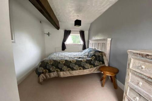 a small bedroom with a bed and a window at Charming apartment with hot tub , Viewly Hill Farm in Norton