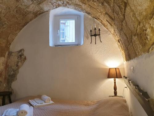 een slaapkamer met een bed in een stenen muur bij Chris Αpartments Old Town in Rhodos-stad
