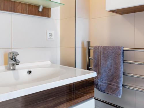 ein Bad mit einem weißen Waschbecken und einem Handtuch in der Unterkunft Modern Apartment in Wismar near Baltic Sea in Wismar