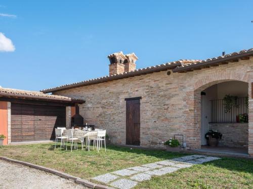 una casa con mesa y sillas en el patio en Belvilla by OYO Borgo Tre, en SantʼAngelo in Vado