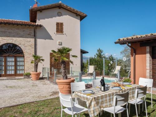 une table et des chaises devant une maison dans l'établissement Belvilla by OYO Borgo Tre, à SantʼAngelo in Vado