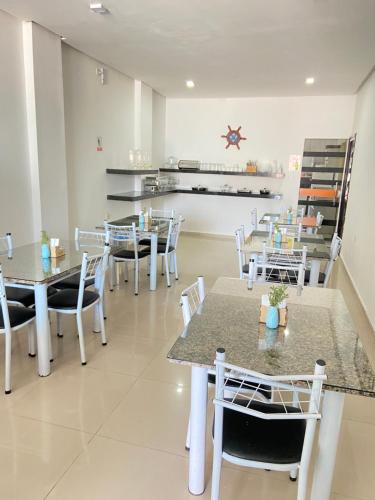 a restaurant with tables and chairs and a kitchen at Pousada Rekinty in Canindé de São Francisco