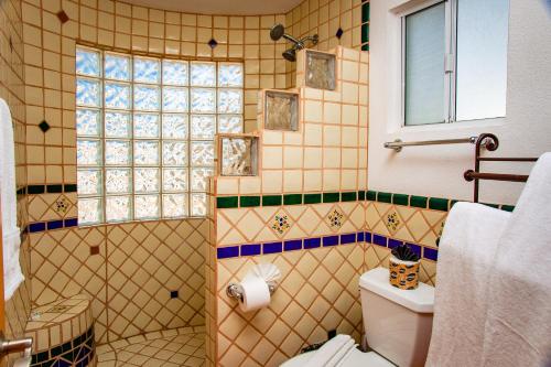 a bathroom with a shower and a toilet and a window at Casa del Sol by FMI Rentals in Puerto Peñasco