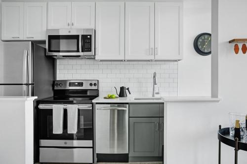a kitchen with white cabinets and a stove top oven at Abode Pittsburgh - Downtown Convention Center in Pittsburgh