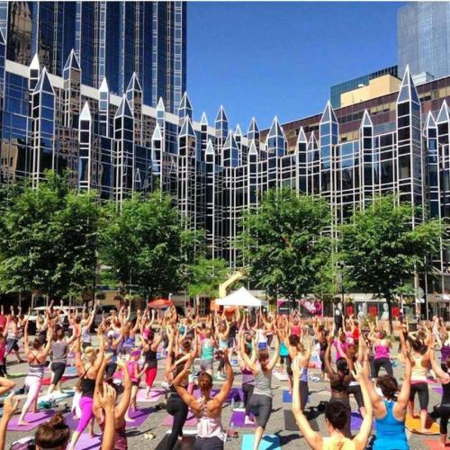 a group of people doing yoga in front of a building at Abode Pittsburgh - Downtown Convention Center in Pittsburgh