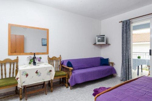 a living room with a purple couch and a table at Apartments Jaki - 150 m from beach in Orebić
