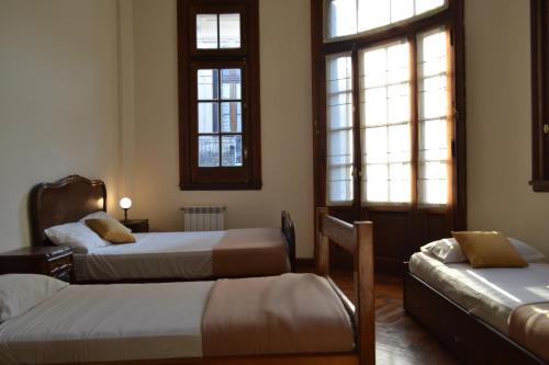 Pokój z 2 łóżkami i 2 oknami w obiekcie Che Argentina Hostel Suites w BuenosAires