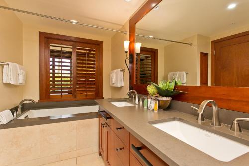 a bathroom with two sinks and a large mirror at Ground floor unit with Private Garden in Kapolei