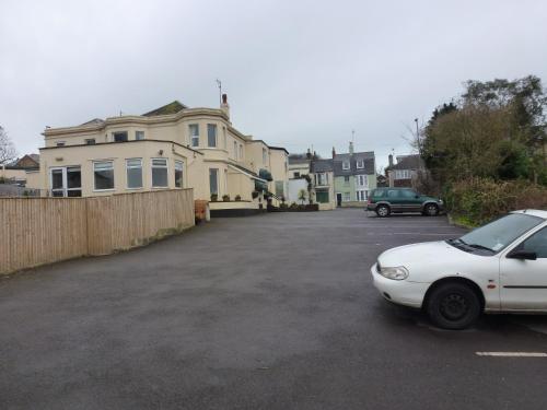 a white car parked in front of a house at The Kingswood Guest House - Adult Only in Weymouth