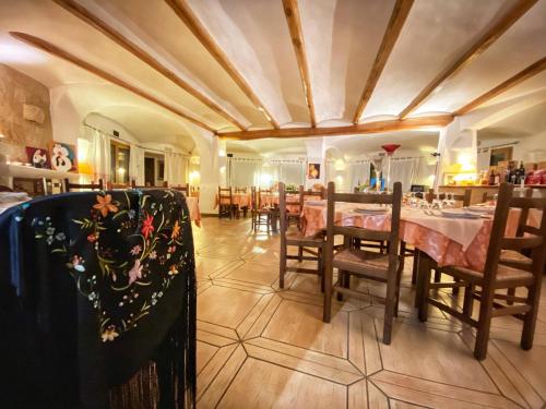 a restaurant with tables and chairs in a room at Locanda Tipica Sa Corte in Oliena