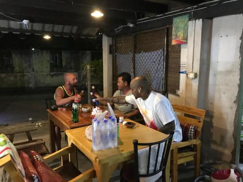 a group of men sitting around a table at Pano Solar Guest House (พาโน โซล่า เกสเฮ้าส์ ) in Trat