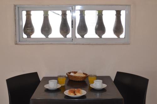 een tafel met bekers en borden eten onder een raam bij Che Argentina Hostel Suites in Buenos Aires