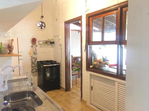 una cocina con fregadero y ventana en Efferus Hostel, en Ubatuba