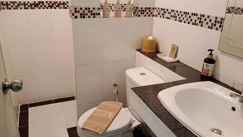 een witte badkamer met een toilet en een wastafel bij Greenfield Residence in Prachin Buri
