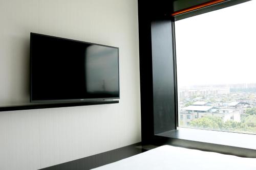 a flat screen tv on a wall next to a window at YaTi by Artyzen Hongqiao Shanghai - Korean Street in Shanghai