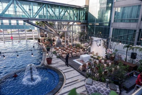 arium de um edifício com uma piscina e uma fonte em Hotel Horison Ultima Bekasi em Bekasi