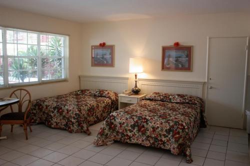 a hotel room with two beds and a table at Beach and Town Motel in Hollywood