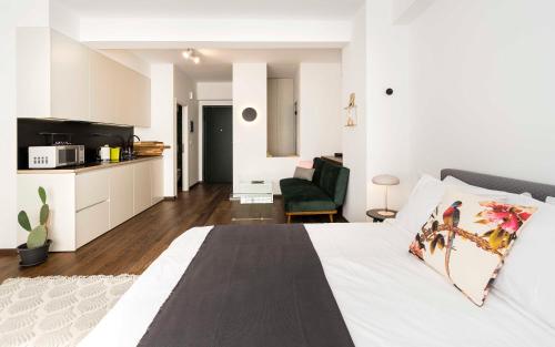 a white bedroom with a bed and a kitchen at Athens' Best Location- Stunning & Spacious Studio in Athens