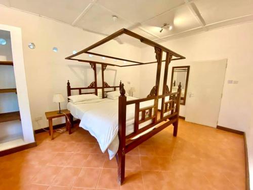 a bedroom with a large wooden bed in a room at Flamboyant Diani Beach in Diani Beach