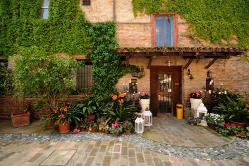 a building with flowers and plants in front of it at Azienda Agricola Palazzo Manzoni in San Zaccaria