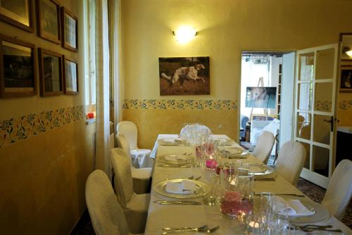 uma sala de jantar com uma mesa longa com pratos e copos em Azienda Agricola Palazzo Manzoni em San Zaccaria