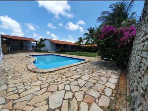 um quintal com uma piscina e um pátio de pedra em Casa na Ilha da Crôa em Barra de Santo Antônio
