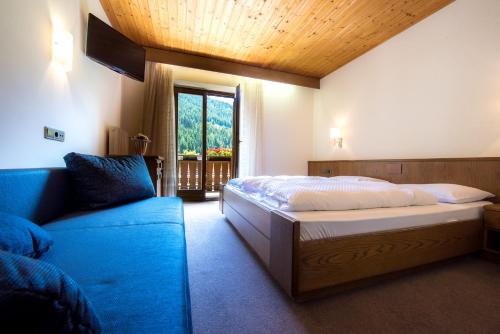 um quarto com uma cama, um sofá e uma janela em Gasthof Rabenstein em Sarentino