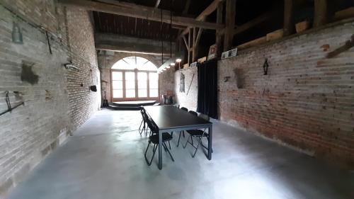 a ping pong table in a room with brick walls at Gite Evidence in Varennes-sur-le-Doubs