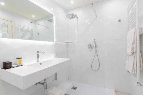 a white bathroom with a sink and a shower at Hotel Columbia Wellness & Spa in Montecatini Terme