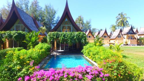 a house with a swimming pool and flowers at Utalay Koh Chang Villas in Ko Chang
