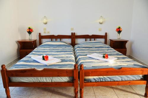 a bedroom with two beds with towels and flowers on them at George's Studios in Archangelos
