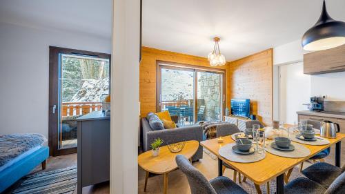un salon avec une table et des chaises et une cuisine dans l'établissement Les Freinets - Apt D103 - BO Immobilier - Châtel, à Châtel