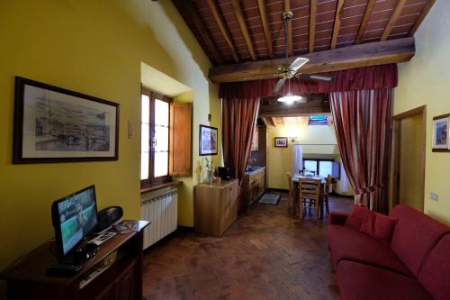 a living room with a red couch and a table at Casa Vacanze Oliviera Pienza in Pienza