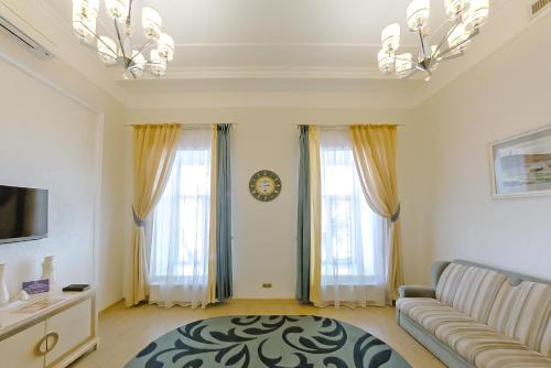 a living room with a couch and two windows at Metro Hotel Apartments in Odesa