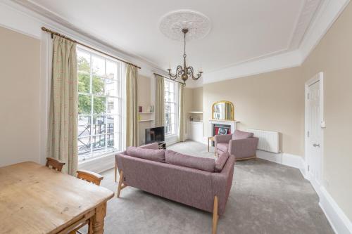 a living room with two couches and a table at Spacious Maisonette with Parking - 10 mins walk from Bath Abbey - 2 Bed & 2 Bath in Bath