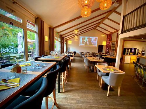une salle à manger avec des tables et des chaises dans un restaurant dans l'établissement FastHôtel Biarritz Bidart Côte-Basque - Un hôtel FH Collection, à Bidart
