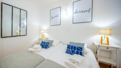 une chambre avec un lit blanc avec des oreillers bleus dans l'établissement Les Freinets - Apt D103 - BO Immobilier - Châtel, à Châtel