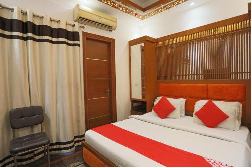 1 dormitorio con 1 cama con almohadas rojas y blancas en OYO 15183 R.J. Residency, en Indirapuram