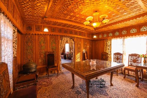 een eetkamer met een tafel en een open haard bij New Jacquline Heritage Houseboats in Srinagar