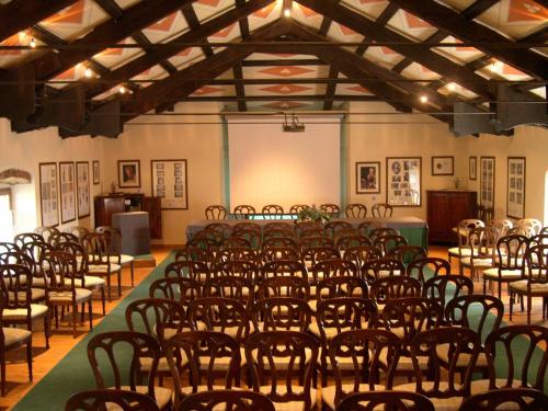 a room filled with rows of chairs in a hall at Castello Di Spessa - Residenze d'epoca in Capriva del Friuli