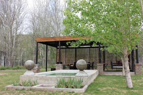 a pavilion with a pool in a park at Furrows Lodge in Nieu-Bethesda
