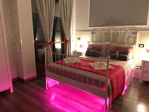 a bedroom with a bed with a pink light on it at Sweet Rome B&B in Rome