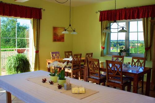 a dining room with a table and chairs and windows at Pension Lammerhof in Unterlamm