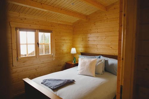 a bedroom with a bed in a wooden cabin at Cosy Log Cabin - The Dookit - Fife in Markinch