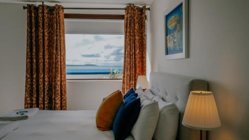 a bedroom with a bed with a view of the ocean at The Wooden House - Room Only Accomodation in Kilmore Quay