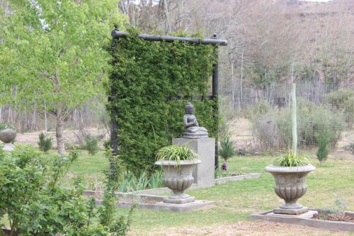 a statue of a woman in a garden at Furrows Lodge in Nieu-Bethesda