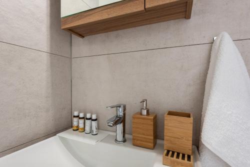 La salle de bains est pourvue d'un lavabo et d'une douche. dans l'établissement Albouro Seafront Apartments, à Kateliós