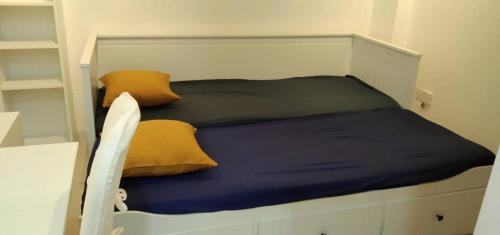 Bett mit gelber und blauer Bettwäsche und Kissen in der Unterkunft PINTARMAN SUITES @ MIRI TIMES SQUARE in Miri